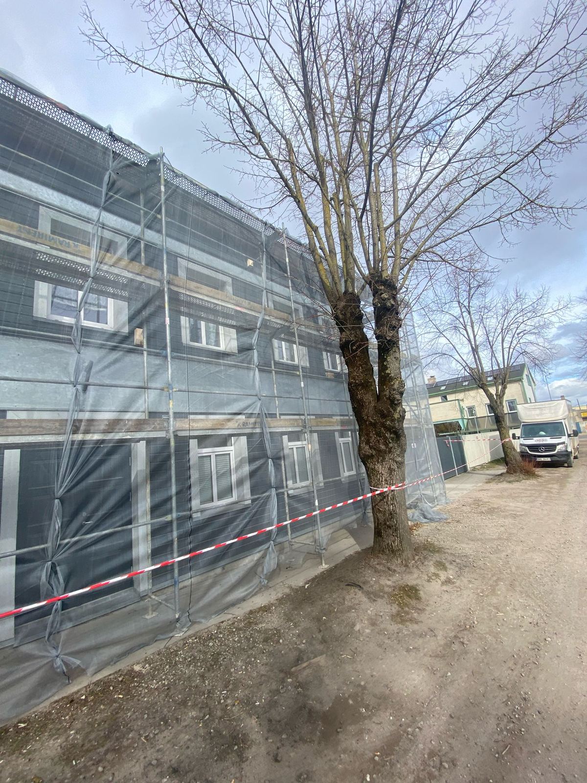Sastatnes ar aizsargplēvi ap māju pirms darbiem